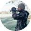 Hunter scouting the landscape with binoculars during a Super Slam of North America expedition